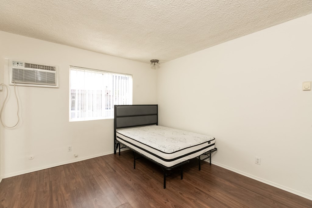 Studio with Hardwood Floors, Mirrored Wardrobe Closet and Kitchen with White Cabinets