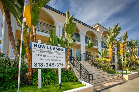 a now leasing sign in front of a house