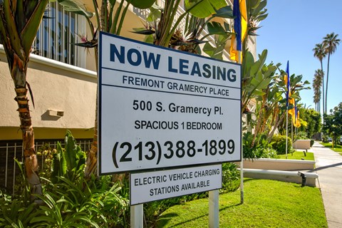 a now leasing sign in front of a building