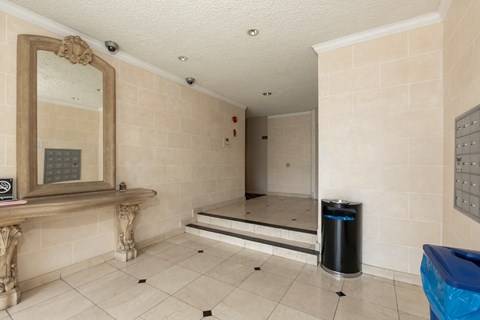 a steam room in a gym with a mirror and a trash can
