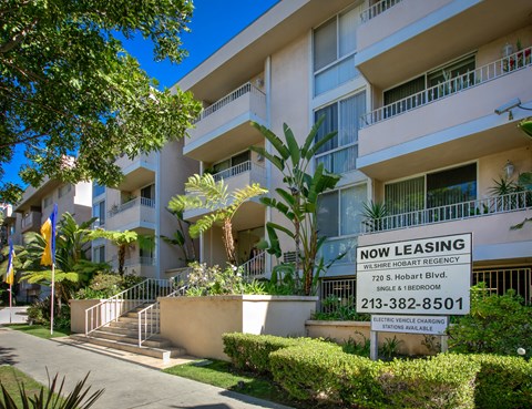 an image of a now leasing sign in front of an apartment building