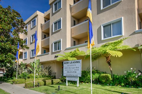 a now leasing sign in front of an apartment building