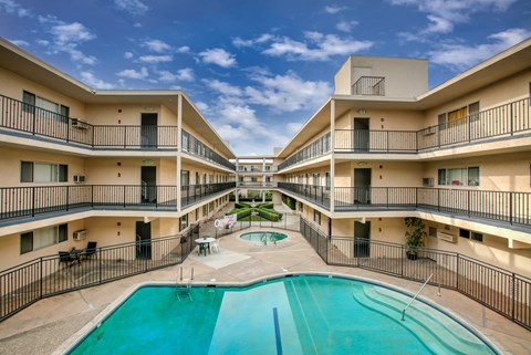 a building with a swimming pool and a courtyard with apartments