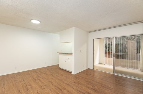 an empty living room with wood flooring and a window