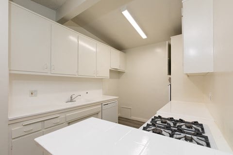 a kitchen with white cabinets and a counter top and a sink