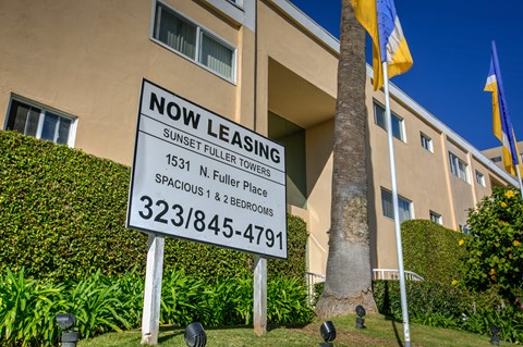 a now leasing sign in front of an apartment building
