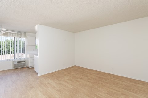 an empty living room with white walls and wood flooring