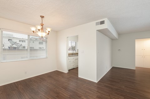 the spacious living room and dining room with a large window and wood flooring
