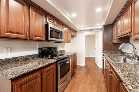 a kitchen with wood cabinets and granite counter tops and stainless steel appliances