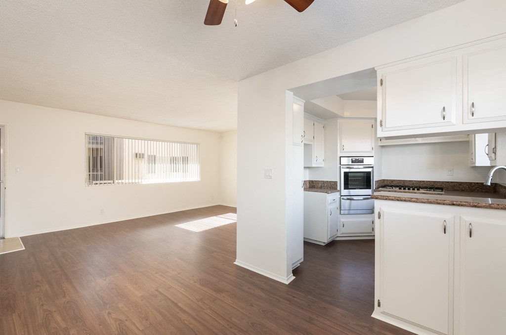 Kitchen with White Cabinets and Living Room with Wood Floor