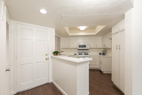 a renovated kitchen with white cabinets and a white counter top