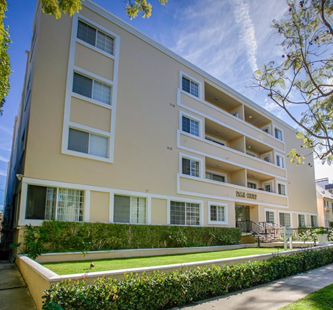 an apartment building with a lawn in front of it