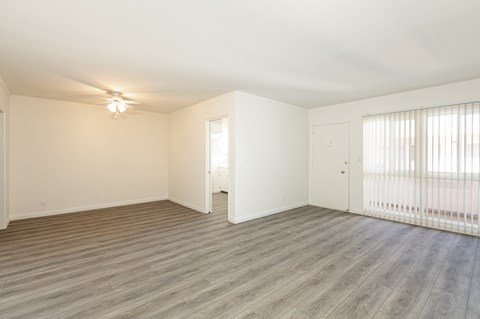 an empty living room with wood flooring and a large window