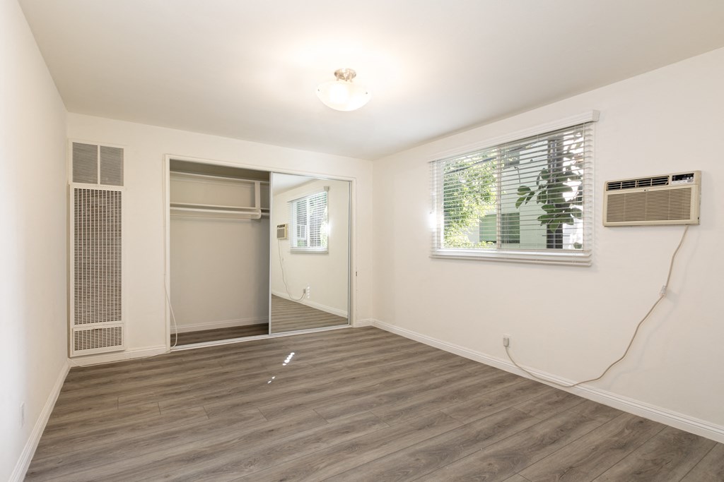 Bedroom with Hardwood Floors and Mirrored Wardrobe Closet