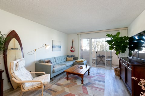 a living room with a couch and a coffee table and a sliding glass patio door