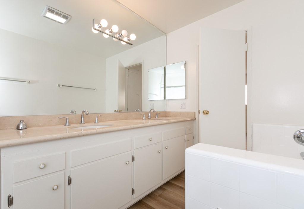 Bathroom with White Cabinets and Hardwood Floors
