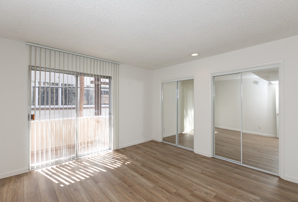 Bedroom with Mirrored Wardrobe Closet and Hardwood Floors