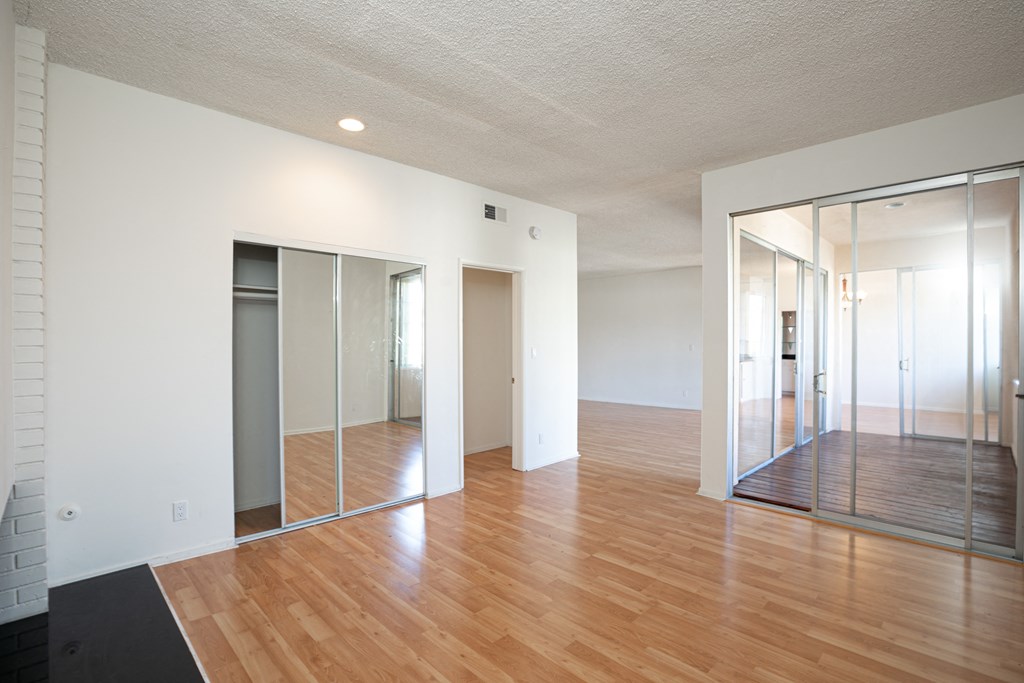 Bedroom with Mirrored Wardrobe Closet and Hardwood Floors
