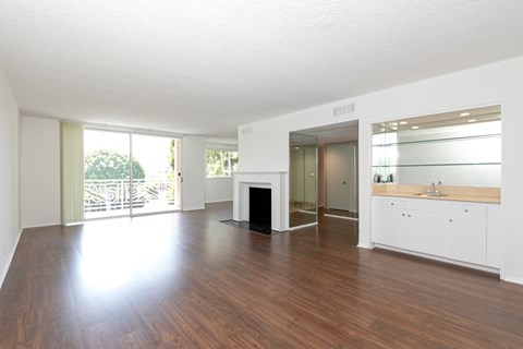 an empty living room with wood floors and a fireplace