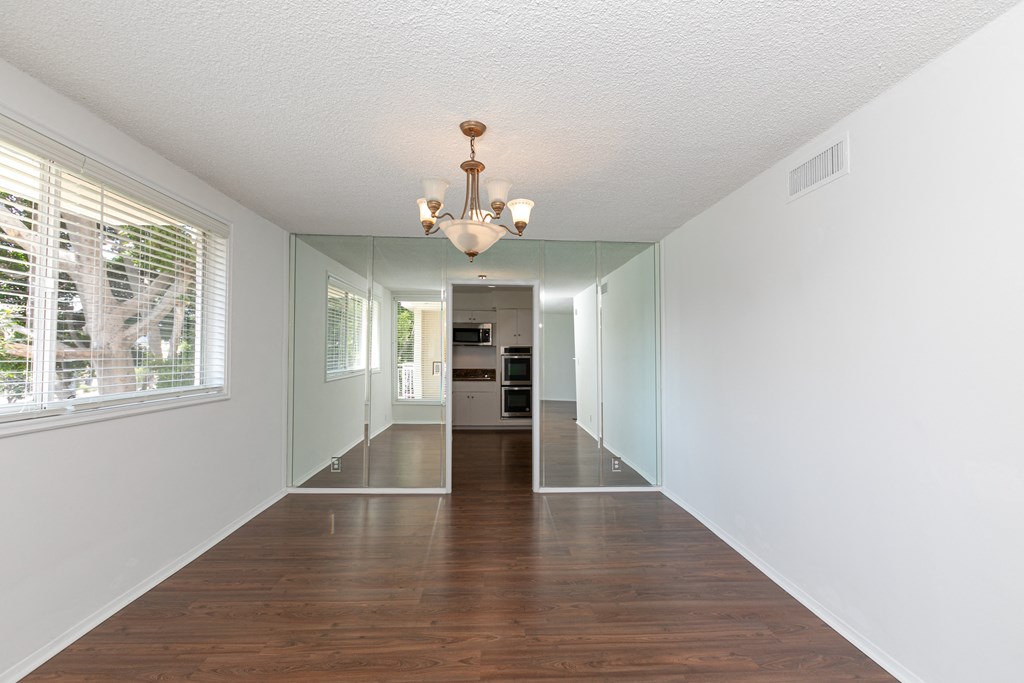 Room with Hardwood Floors and Mirrored Wall