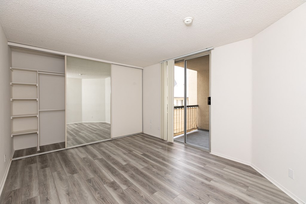 Bedroom with Hardwood Floors and Mirrored Wardrobe Closet