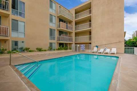 a swimming pool in front of an apartment building