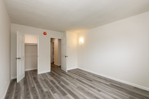 an empty living room with wood flooring and white walls