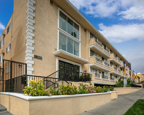 an exterior view of a building with a sidewalk and flowers