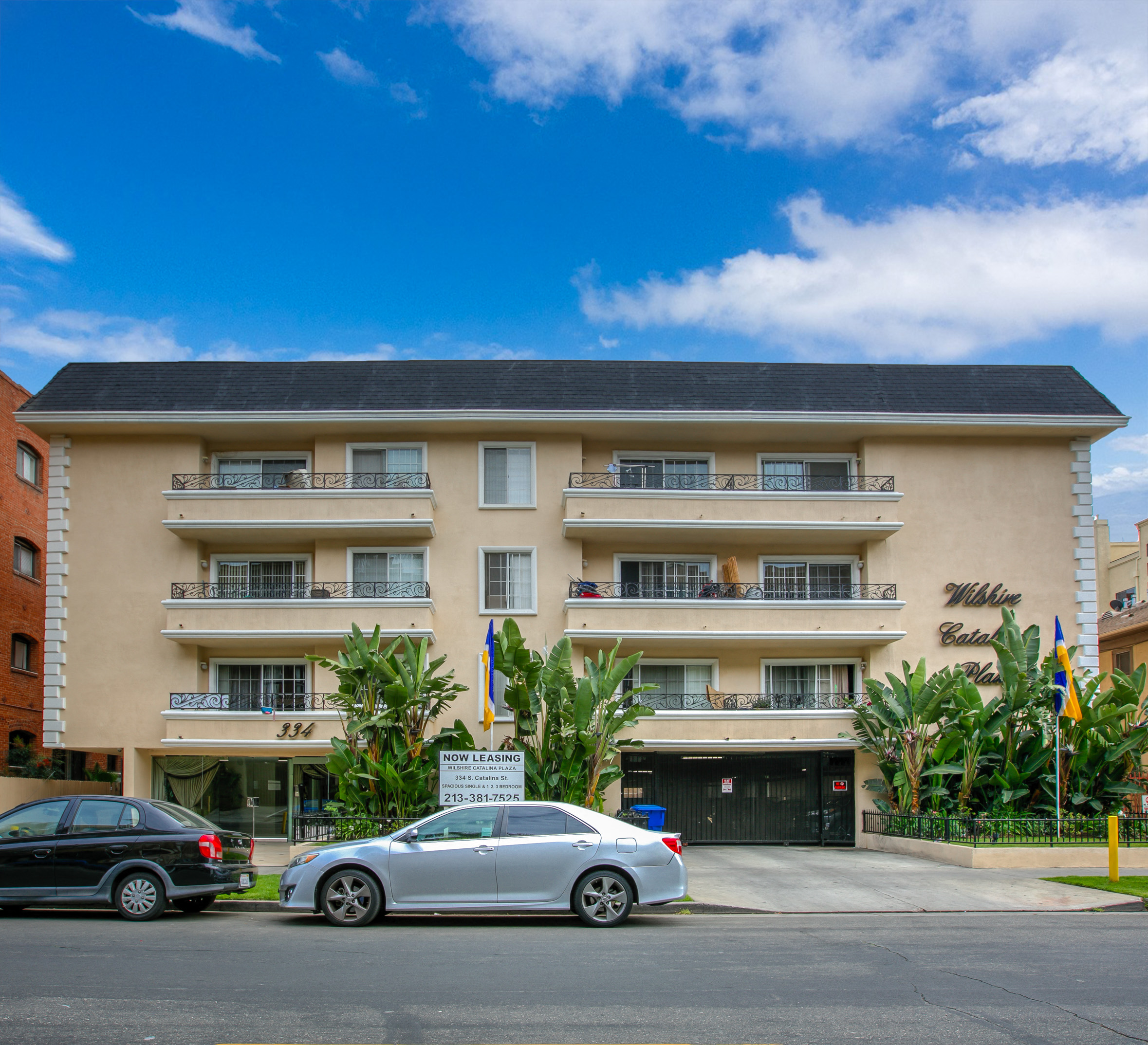 a large apartment building with cars parked in front of it