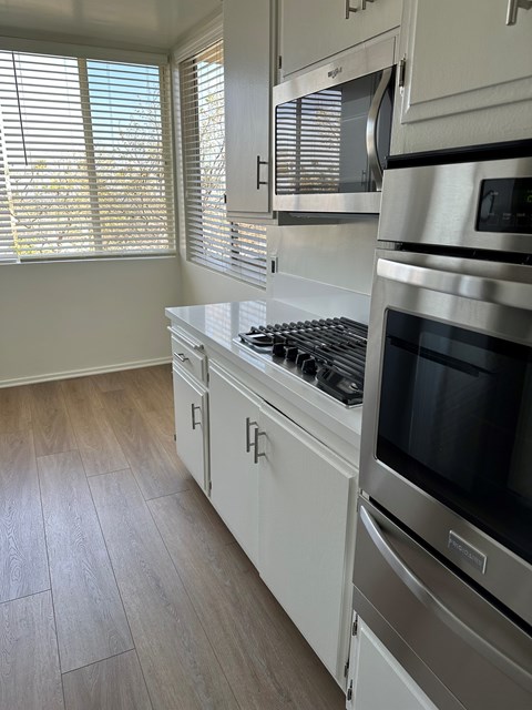 A kitchen with a stove top oven and a microwave above it.