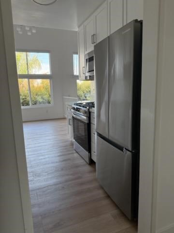 Kitchen with black refrigerator and wood flooring
