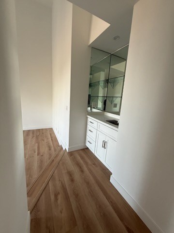 Wet bar with wood flooring