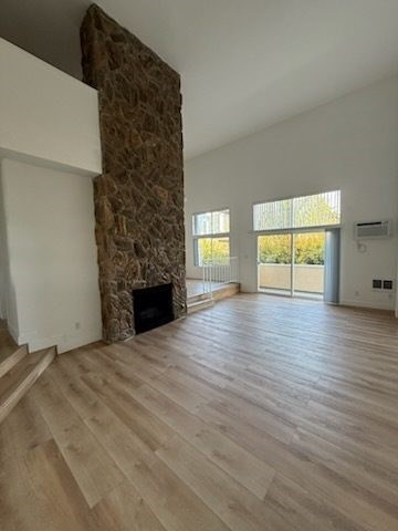 Living room with stone fireplace and wood flooring