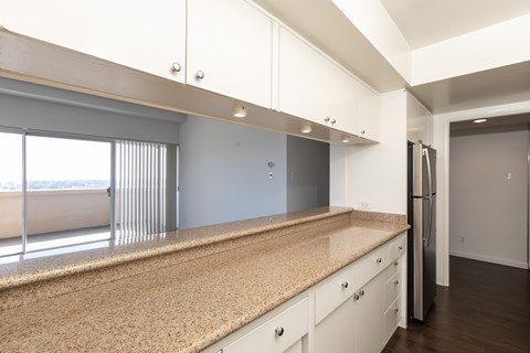 A kitchen with white cabinets and a granite countertop.