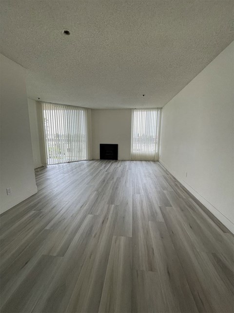an empty living room with wooden floors and a fireplace