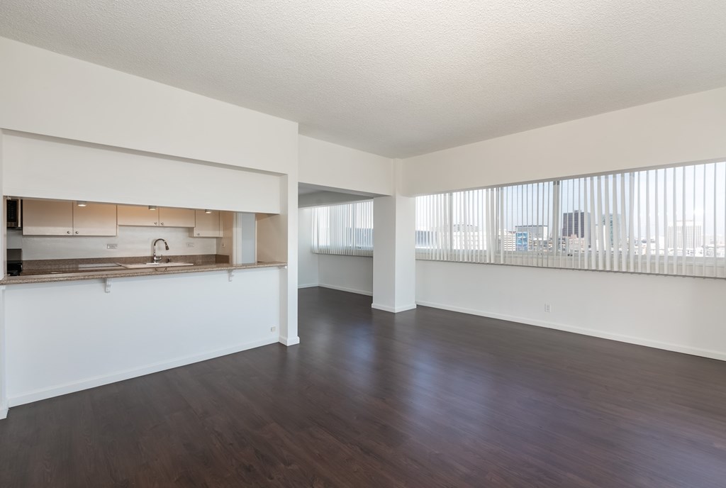 A large empty room with wooden floors and white walls.