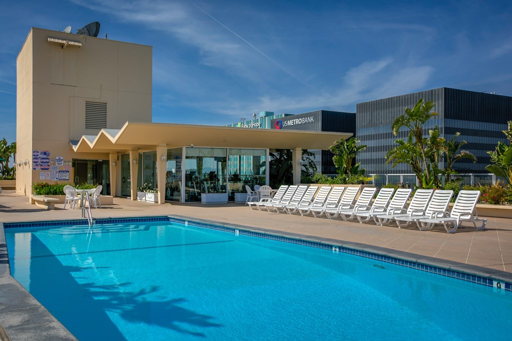 A swimming pool in front of a building with a sign that reads "Asterodinamika".