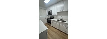 A kitchen with white cabinets and a black stove top oven.