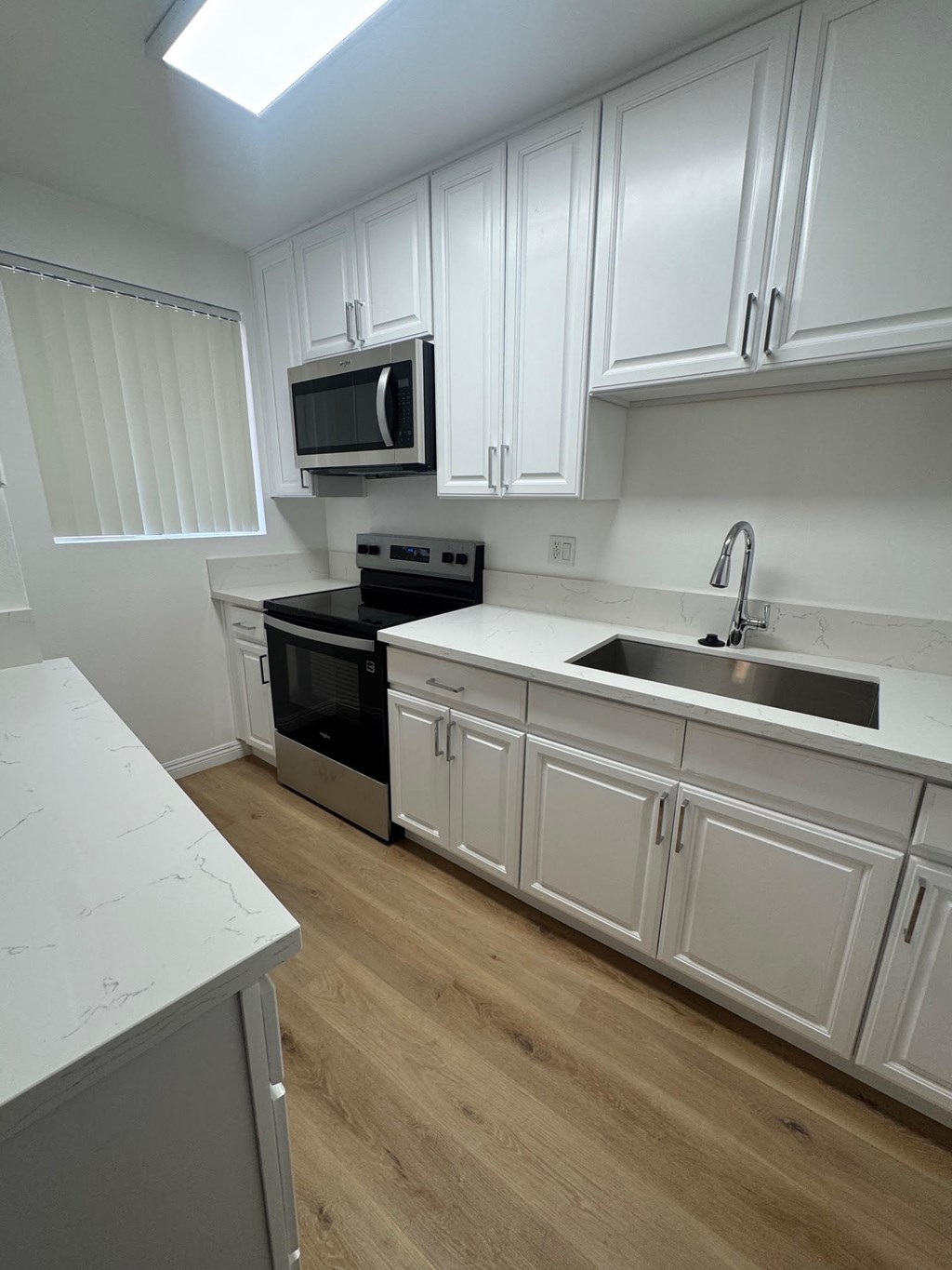 A kitchen with white cabinets and a black stove top oven.