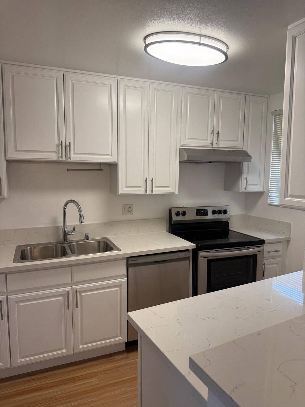 A kitchen with white cabinets and a black stove.