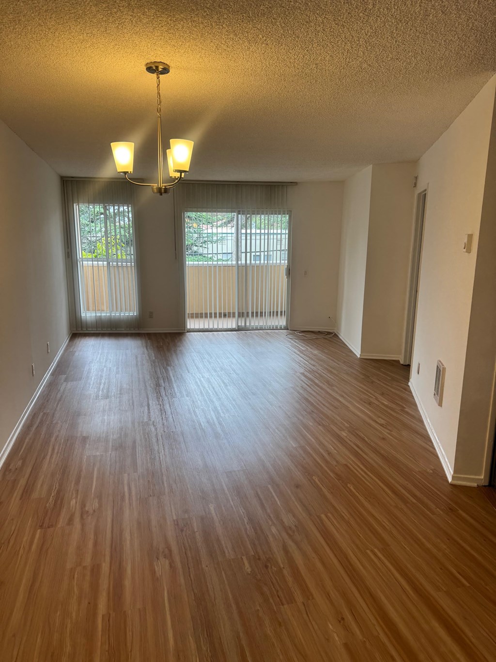 A room with wooden floors and a chandelier.