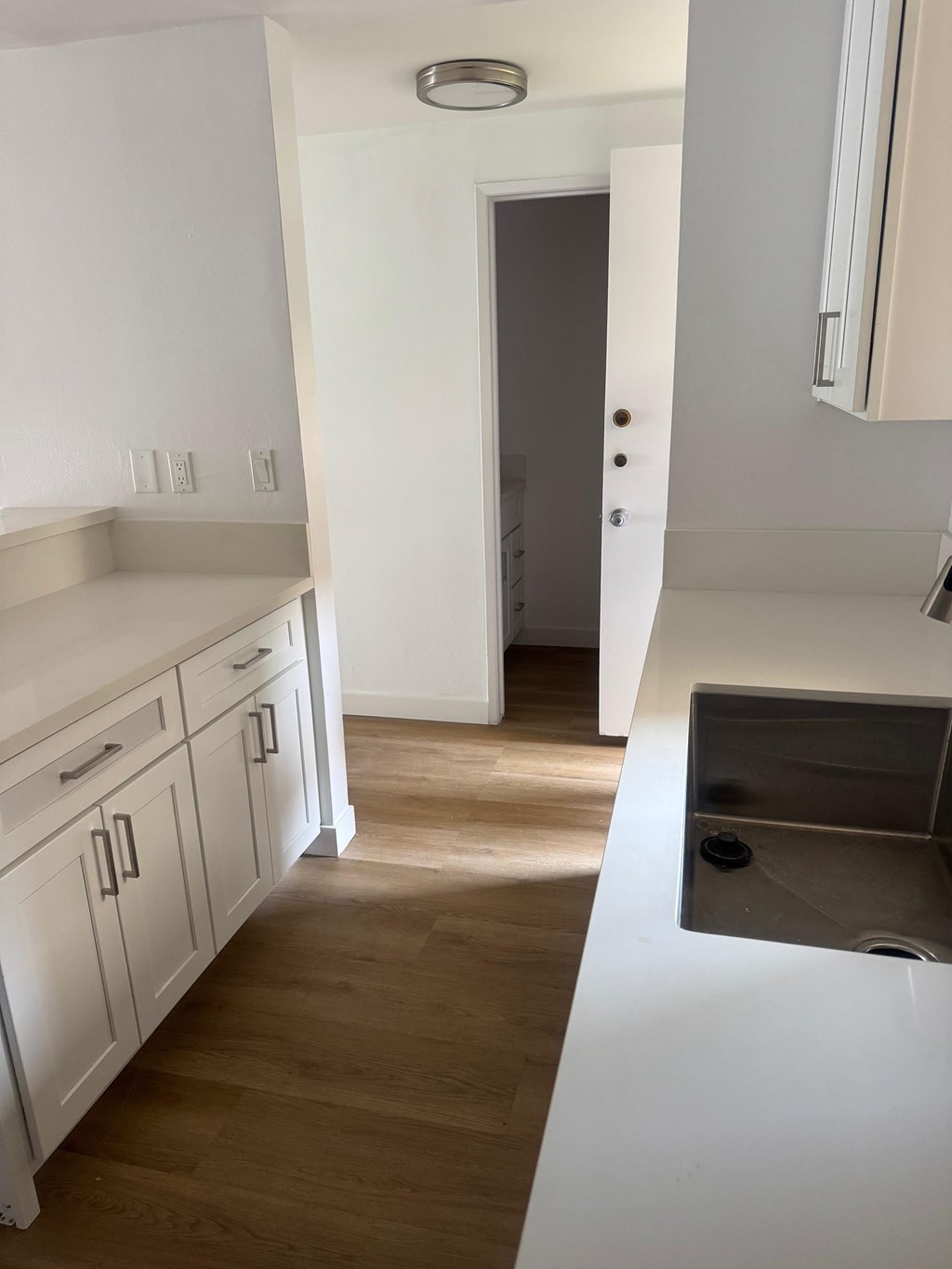 Kitchen with White Cabinets and  Wooden Floor.