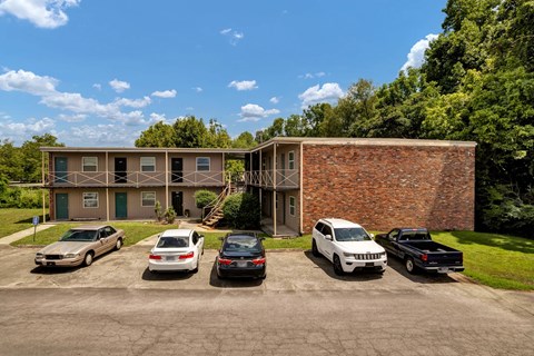 A parking lot with cars and a building in the background.
