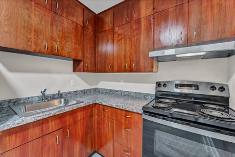 A kitchen with brown cabinets and a stove top oven.