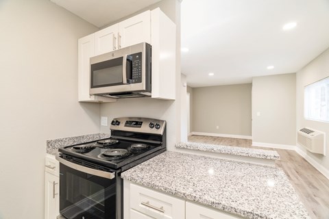 A kitchen with a stove and microwave.