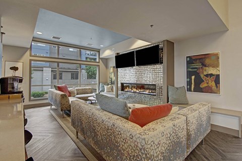 A modern living room with a large couch and a fireplace.