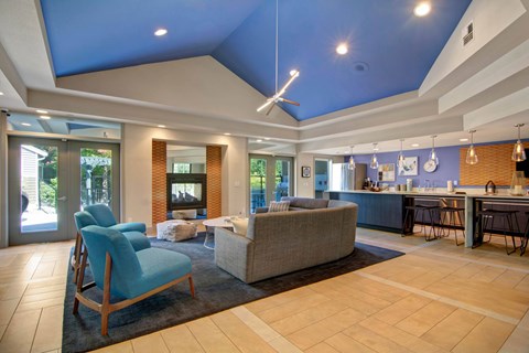 A living room with a blue chair and a grey couch.
