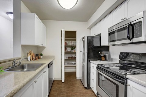 A kitchen with white cabinets and black appliances.