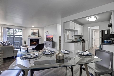 A modern dining room with a glass table and chairs.