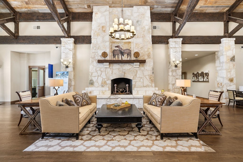 living room with couches and a table and a fireplace at Lakeline East Apartments, Texas